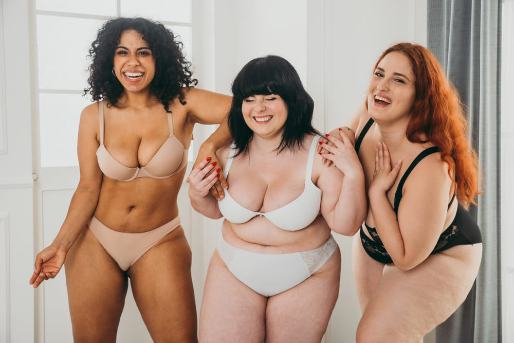 Three women posing for body positive studio portraits.