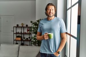 Middle age caucasian man smiling confident drinking coffee at home
