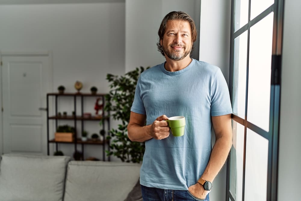 Middle age caucasian man smiling confident drinking coffee at home
