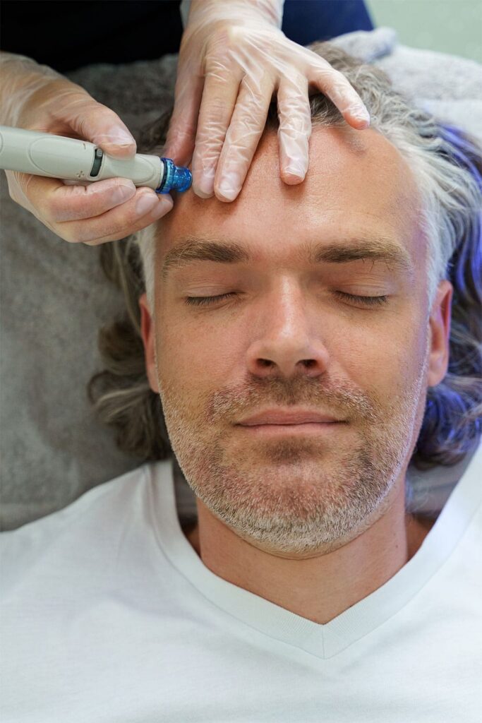 Middle aged male client during deep facial cleansing in a cosmetology clinic