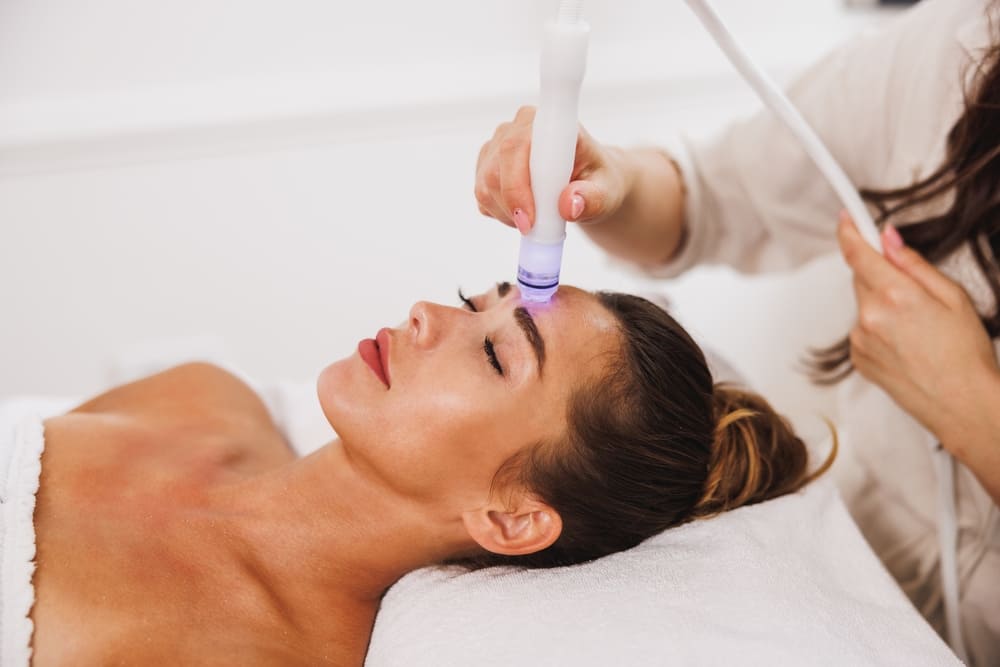 Beautiful young woman enjoying a hydrafacial treatment at the beauty salon.