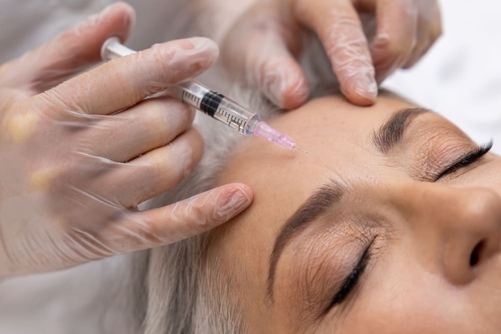 Mature woman having filler injections at beauty clinic