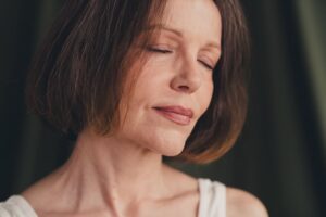 Close up unretouched photo of old lady close eyes feel tenderness isolated green color linen background