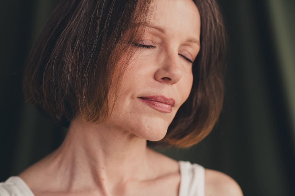 Close up unretouched photo of old lady close eyes feel tenderness isolated green color linen background