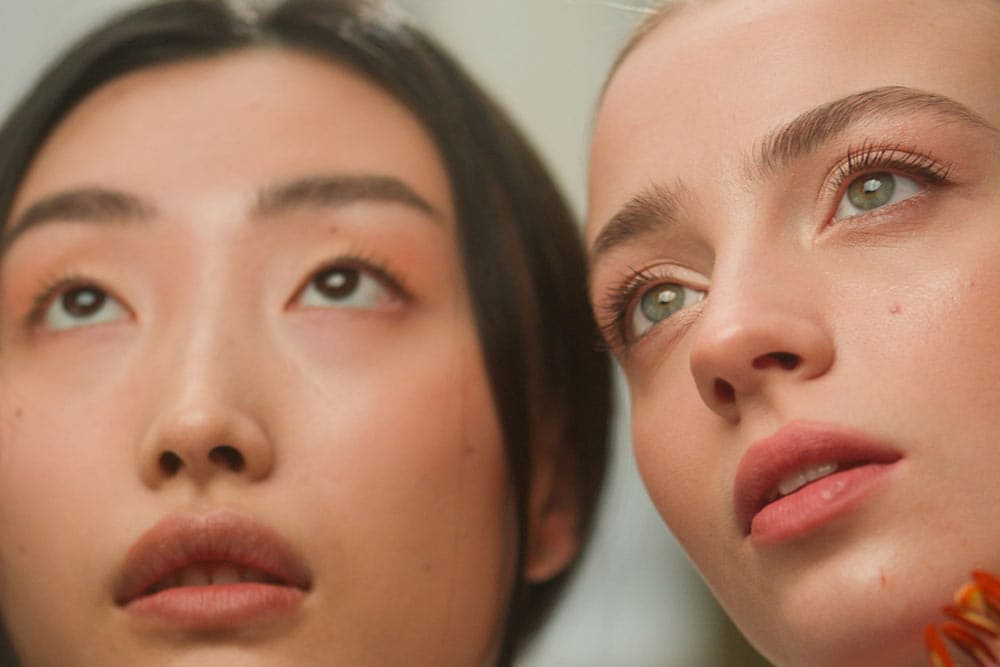 Chinese Caucasian females women holding flowers near faces