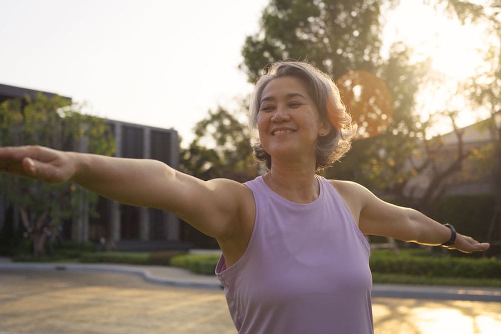 happy old woman yoga body pose zen calm stress relief outdoor nature public park